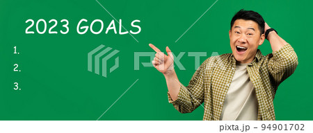 Cheerful shocked adult asian man point finger at 2023 goals with light bulbs, checklist with free space Cheerful shocked adult asian man point finger at 2023 goals with light bulbs, checklist with free space 94901702