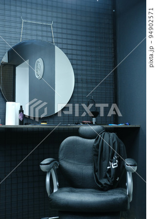 Client's chair in barber shop from black leather in black interior 94902571