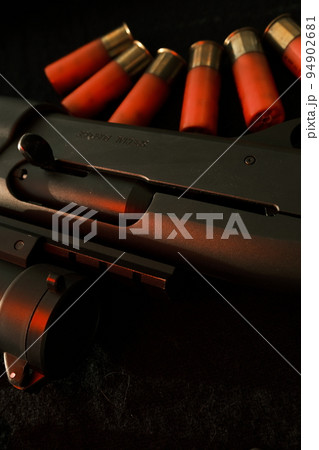 Closeup shotgun shutter. Hunting semi-automatic shotgun with wooden butt on dark background Closeup shotgun shutter. Hunting semi-automatic shotgun with wooden butt on dark background 94902681