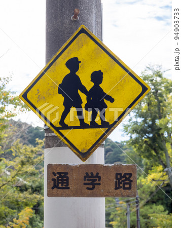 道路標識。本標識(警戒標識)「学校、幼稚園、保育所等あり」と、「通学路」と書かれた補助標識。 94903733