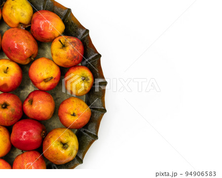 Ripe red small apples Ranetka on a metal plate, on a white background. Isolated background 94906583