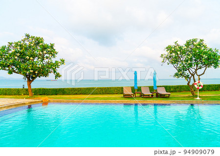 chair pool and umbrella around swimming pool 94909079