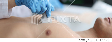 Doctor performs chest ultrasound on man in hospital closeup Doctor performs chest ultrasound on man in hospital closeup 94913350