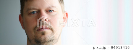 Portrait of young sad man in front of window 94913416