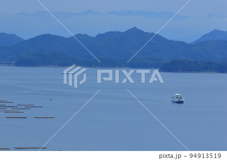 雲上の四国山脈と穏やかな瀬戸内海を行き交うフェリー 94913519