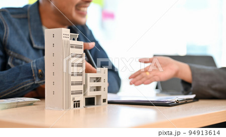 A modern building or condominium model is on a table. cropped and close-up image A modern building or condominium model is on a table. cropped and close-up image 94913614