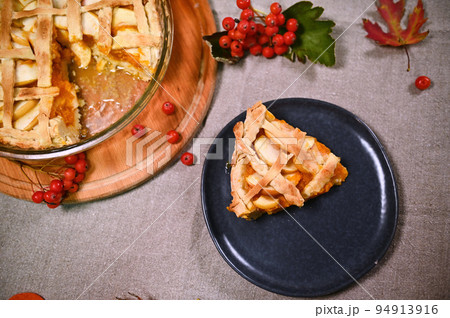 Flat lay. Still life with a slice of freshly baked homemade pumpkin apple pie, with a crispy crust on a blue navy ceramic plate. Thanksgiving Day. Halloween. Autumn festival. Festive baking concept 94913916