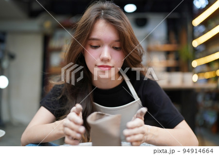 Beautiful woman making ceramic pottery on wheel, close-up. woman in freelance, business, hobby. 94914664
