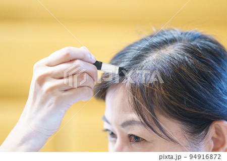 伸びてきた白髪に色を塗る中年女性 グレイヘアへの移行 伸びてきた白髪に色を塗る中年女性 グレイヘアへの移行 94916872