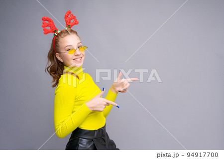 Photo of funny young woman in christmas deer costume wearing yellow glasses Photo of funny young woman in christmas deer costume wearing yellow glasses 94917700