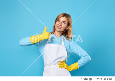 smiling blonde woman in yellow rubber gloves showing ok smiling blonde woman in yellow rubber gloves showing ok 94918348