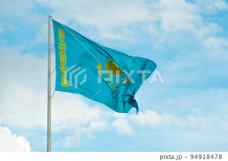 Flag of Kazakhstan on sky background. Waving flag of Republic of Kazakhstan. Fabric textures flowing flag of Kazakhstan. 94918478