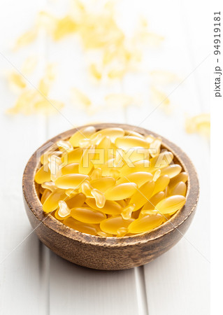 Fish oil capsules. Yellow omega 3 pills in bowl on white table. Fish oil capsules. Yellow omega 3 pills in bowl on white table. 94919181