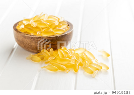 Fish oil capsules. Yellow omega 3 pills in bowl on white table. Fish oil capsules. Yellow omega 3 pills in bowl on white table. 94919182