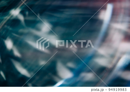 Light flare motion. Defocused glow. Old film overlay. Blur blue green orange color rays texture on dark black abstract free space background. 94919983