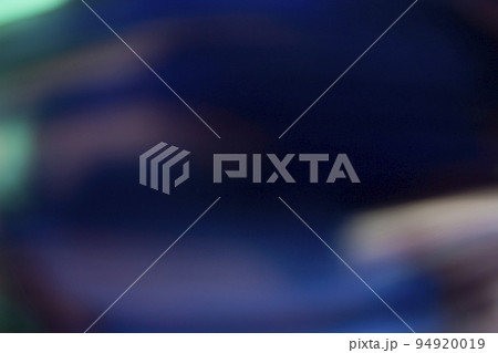 Lens flare overlay. Light leak. Blur glow. Defocused neon blue green orange color flecks texture on dark black abstract copy space background. 94920019