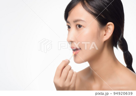 Portrait young asian woman looking mirror applying makeup lipstick at room 94920639