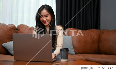 Gorgeous Asian female freelancer or businesswoman working from home, using laptop 94921337