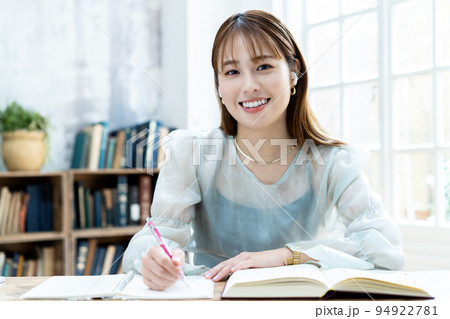 イヤホンをして勉強する若い女性 イヤホンをして勉強する若い女性 94922781