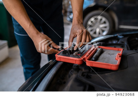 Mechanic selecting an optical tool for work Mechanic selecting an optical tool for work 94923068