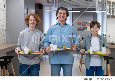 School boys and their teaher having lunch together at school canteen School boys and their teaher having lunch together at school canteen 94923457