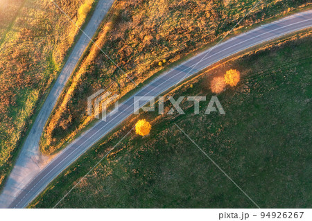 Aerial view of winding road in autumn forest at sunset 94926267