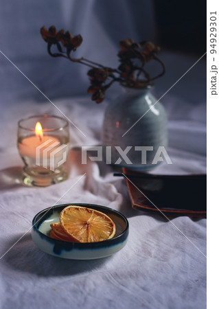 Vertical shot of an incense Stick on a ceramic platter in candlelight for a relaxing and cozy autumn mood 94929301