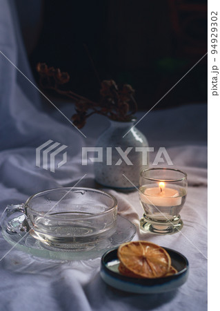Scented candle and dried lemon slices for a relaxing autumn aroma and aesthetic 94929302