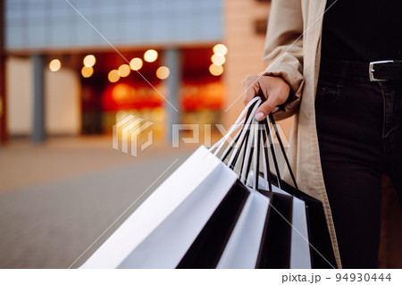 Young woman with shopping bags near mall. Spring Style. Consumerism, purchases, shopping, lifestyle. Young woman with shopping bags near mall. Spring Style. Consumerism, purchases, shopping, lifestyle. 94930444