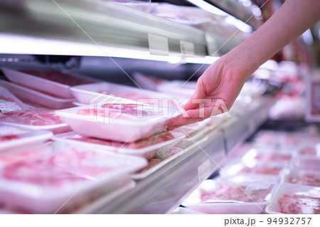 スーパーマーケットで肉を手に取る女性客の手 94932757