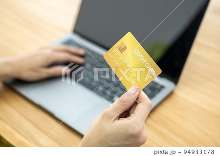 Asian Woman holding bank business credit card with computer laptop, Woman hand holding bank credit card, Paying using credit card, Asian shopaholic shopping online lifestyle. 94933178