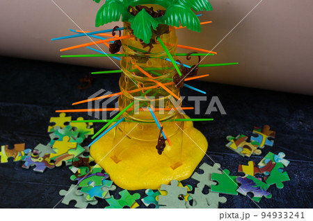 Board game with monkeys and palm tree. Plastic set for children to play. Pulling sticks one at a time until all monkeys fall 94933241