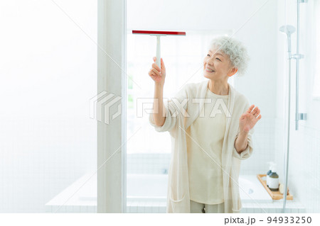 バスルームで水切りワイパーを使う女性 バスルームで水切りワイパーを使う女性 94933250
