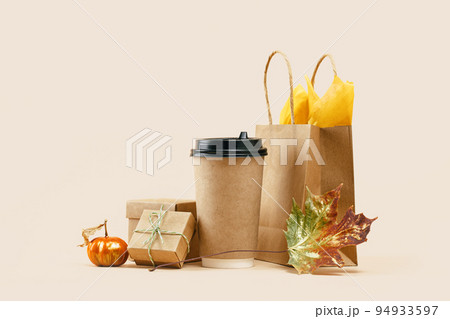 Fall Gift or Sale concept. Shopping paper bag, paper drink cup with gift boxes and pumpkin. Copy space. Thanksgiving. Packaging. Box order delivery. Mockup 94933597