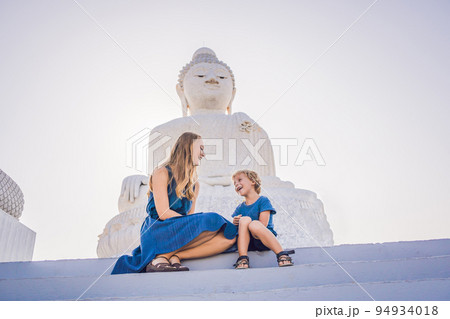 Mother and son tourists on the Big Buddha statue. Was built on a high hilltop of Phuket Thailand Can be seen from a distance Mother and son tourists on the Big Buddha statue. Was built on a high hilltop of Phuket Thailand Can be seen from a distance 94934018