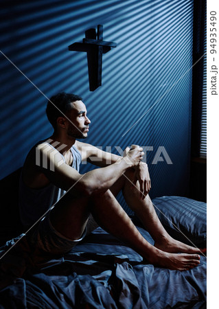 Young depressed man sitting on bed while staying awake till morning 94935490