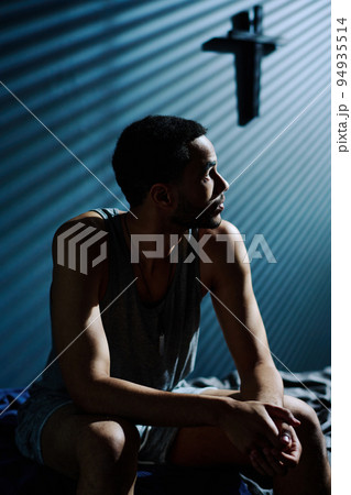 Young tired and unhappy man looking at moonlight coming through window 94935514