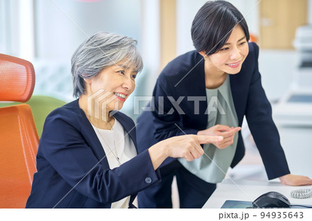 オフィスで部下とミーティングするシニアビジネスウーマン オフィスで部下とミーティングするシニアビジネスウーマン 94935643