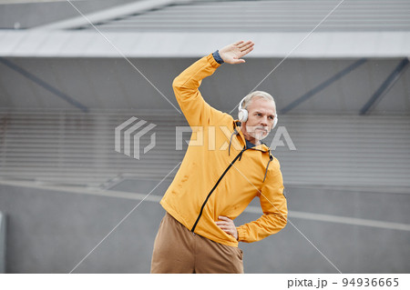 Active Mature Man Stretching In Stadium Active Mature Man Stretching In Stadium 94936665