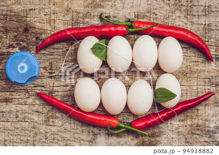Eggs and red peppers in the form of a mouth with teeth. Leaves are stuck to the teeth and dental floss. Cleaning your teeth with dental floss Eggs and red peppers in the form of a mouth with teeth. Leaves are stuck to the teeth and dental floss. Cleaning your teeth with dental floss 94938882
