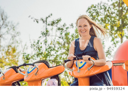 Beautiful, young woman having fun at an amusement park 94939324