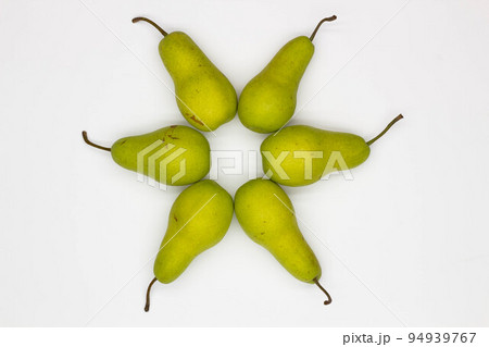 Pears laid out in a circle. Star made from pears on white background. Ripe pears laid out in the shape of an eight-pointed Star.  Sweet and juicy pears. Close-up. Top view 94939767