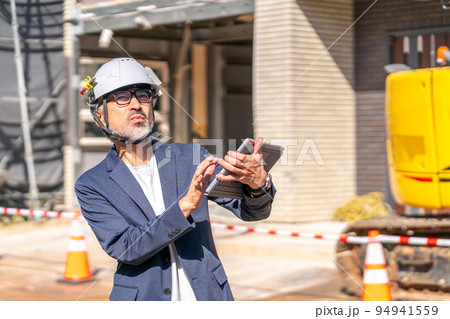 設計図面と建築現場を照合する工事監理者　白髪　ひげ 94941559
