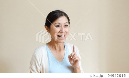 嬉しそうに人差し指を立てる中年女性 嬉しそうに人差し指を立てる中年女性 94942016