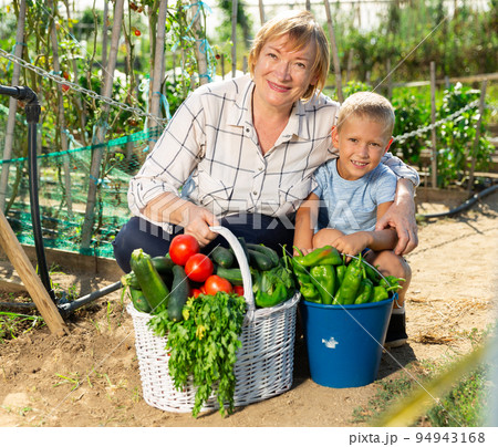 Mature woman with boy posing in garden 94943168