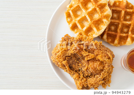 fried chicken waffle with honey or maple syrup fried chicken waffle with honey or maple syrup 94943279
