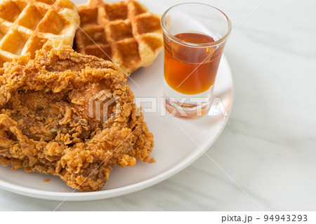 fried chicken waffle with honey or maple syrup fried chicken waffle with honey or maple syrup 94943293