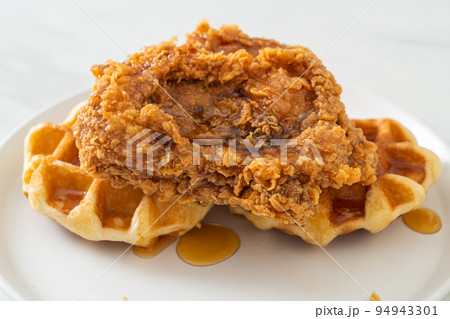 fried chicken waffle with honey or maple syrup fried chicken waffle with honey or maple syrup 94943301
