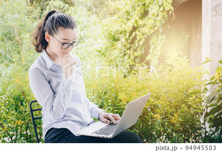 Portrait of young mixed race businesswoman using her laptop and thinking something. Portrait of young mixed race businesswoman using her laptop and thinking something. 94945583