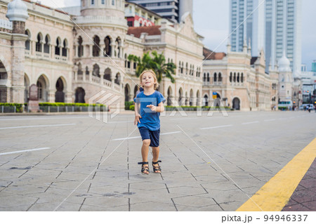 Boy on background of Sultan Abdul Samad Building in Kuala Lumpur, Malaysia. Traveling with children concept Boy on background of Sultan Abdul Samad Building in Kuala Lumpur, Malaysia. Traveling with children concept 94946337